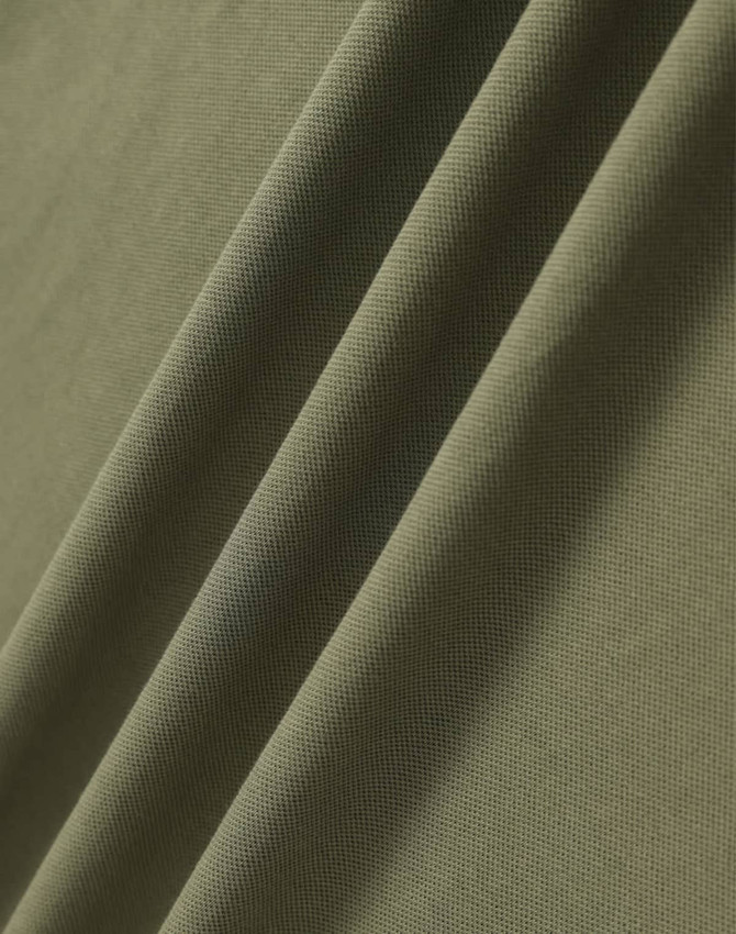 A close-up of a textured, ultrafine cotton pique fabric in olive green, featuring subtle folds.