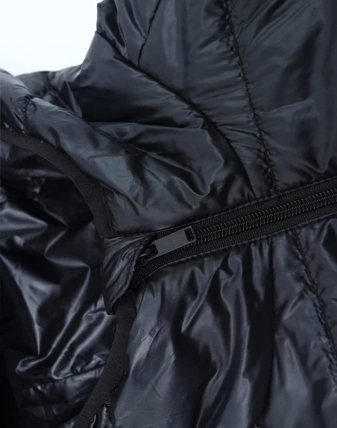 A close-up of a lightweight hooded puffer jacket in black, showcasing its zipper and inner lining.