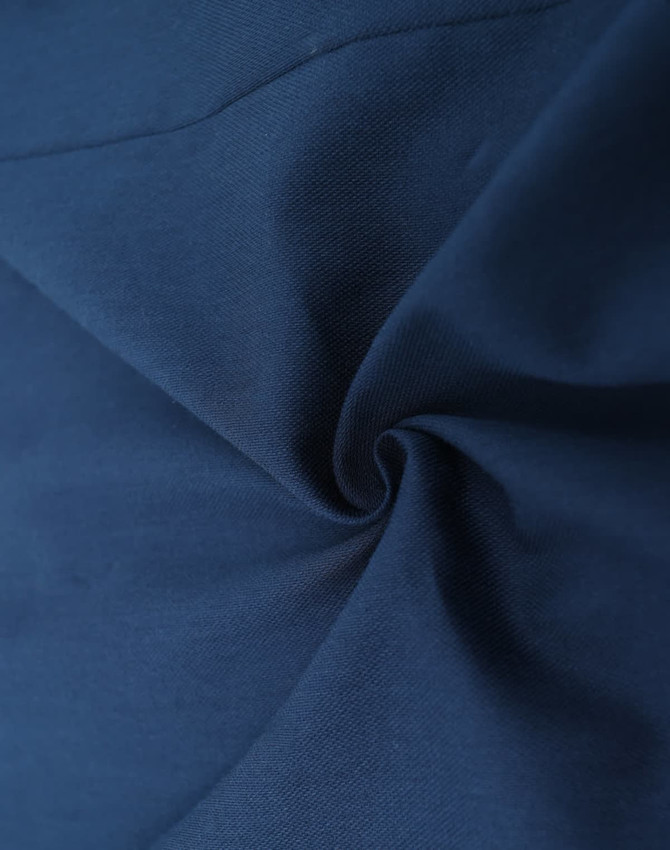 A close-up of a dark navy cotton blend fabric, showcasing smooth texture and softness. Features a logo in the corner.