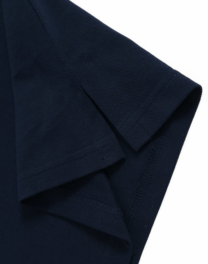 A navy blue ultrafine cotton pique polo with detailed stitching and a folded sleeve. It features a branding logo.