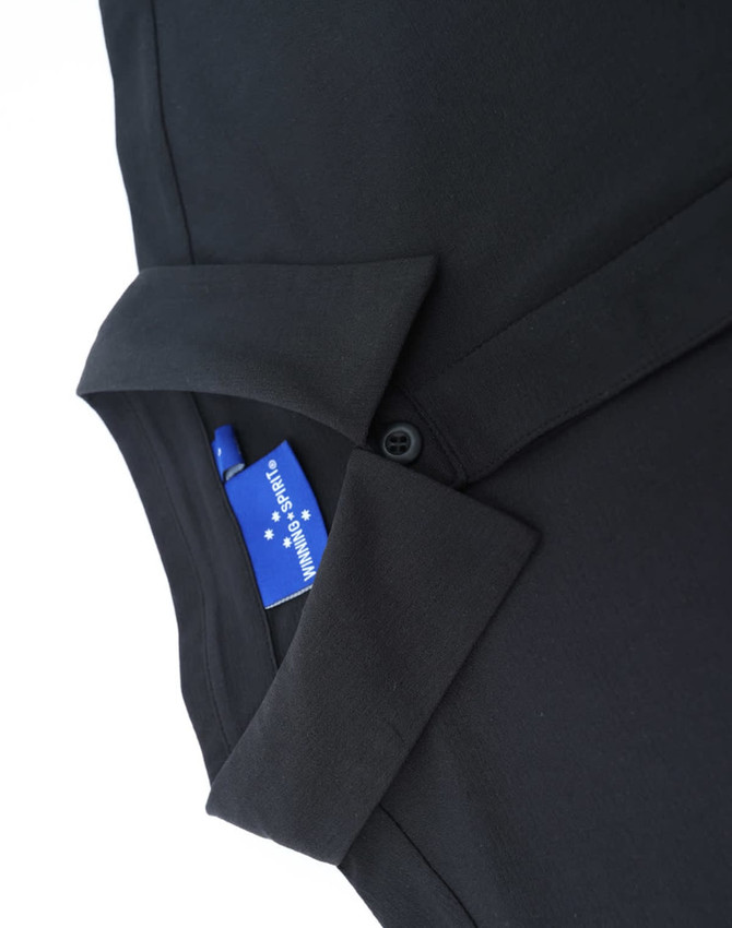 A black polo shirt with a collar, featuring a button and a tag inside.
