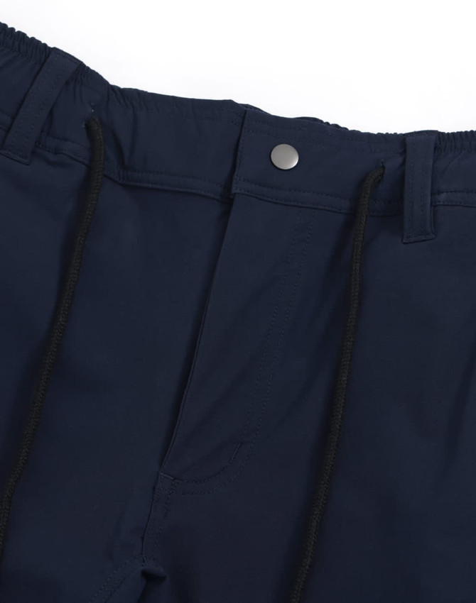A pair of navy blue water repellent flexi work pants featuring a button and drawstring waist. The garment has a logo.