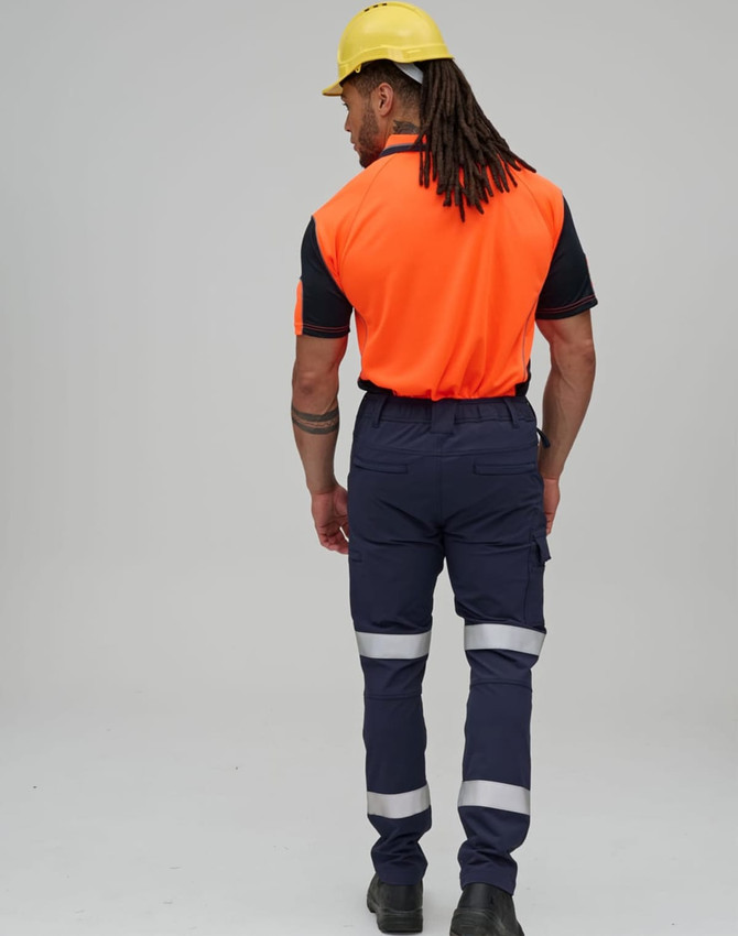 Flexi work pants in navy with reflective tapes, worn by a person in an orange shirt and yellow hard hat.