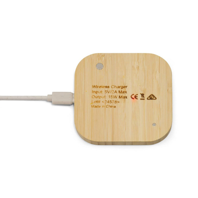 A square wireless charger made of bamboo with a cable connected, featuring a logo and minimal design.