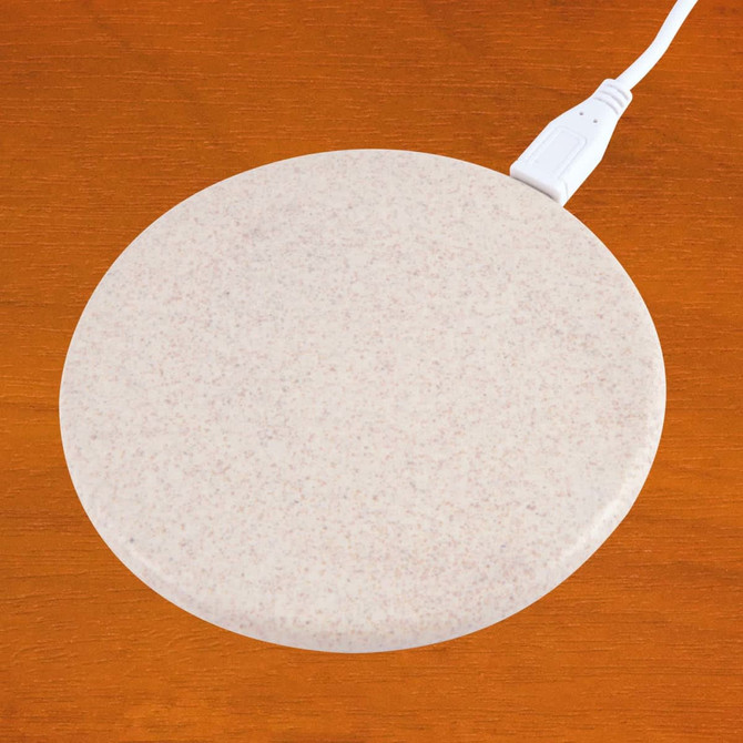 A wireless charger with a round, beige surface and a white charging cable attached.