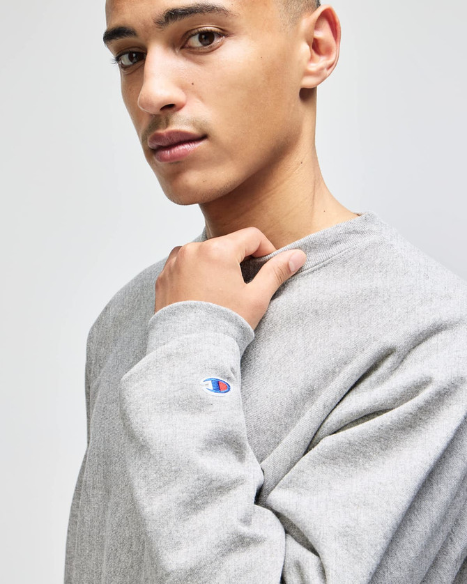 A grey Champion Reverse Weave® adult crew sweatshirt, featuring a small logo on the sleeve.