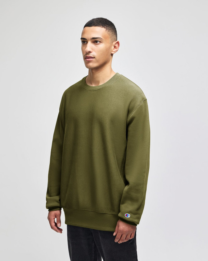 An olive green Champion Reverse Weave® adult crew sweatshirt with a logo displayed on the sleeve.