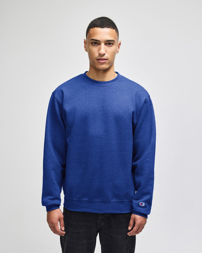 A blue crewneck sweatshirt is worn by a model, featuring a logo on the sleeve.