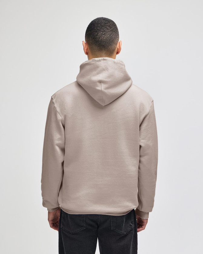 A beige pullover hooded sweatshirt with a loose fit and a hood, viewed from the back.
