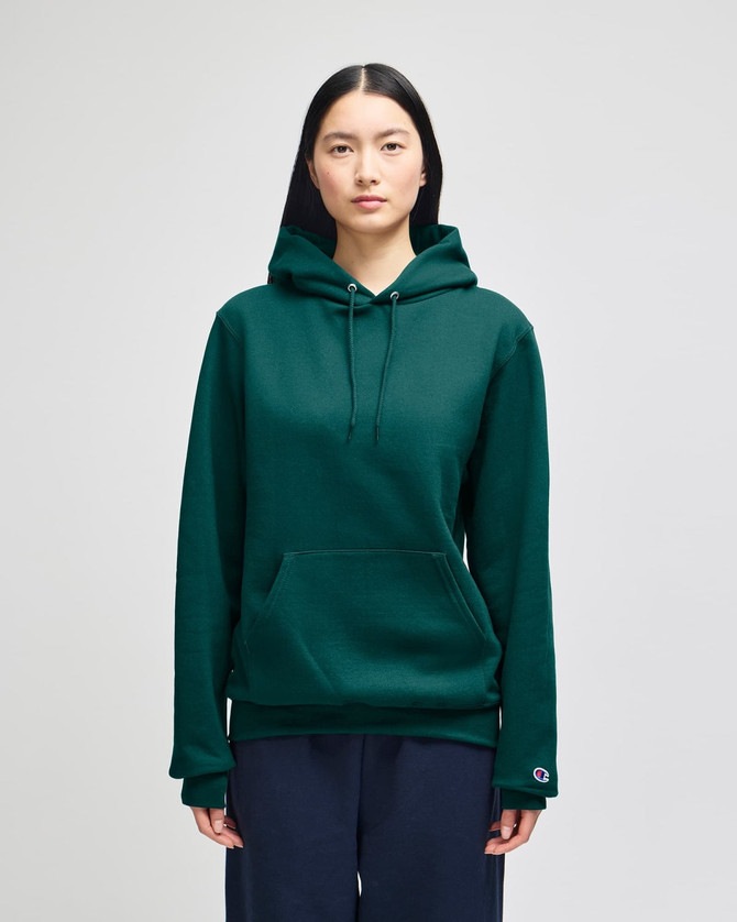 A green hooded sweatshirt featuring a front pocket and a logo on the sleeve.
