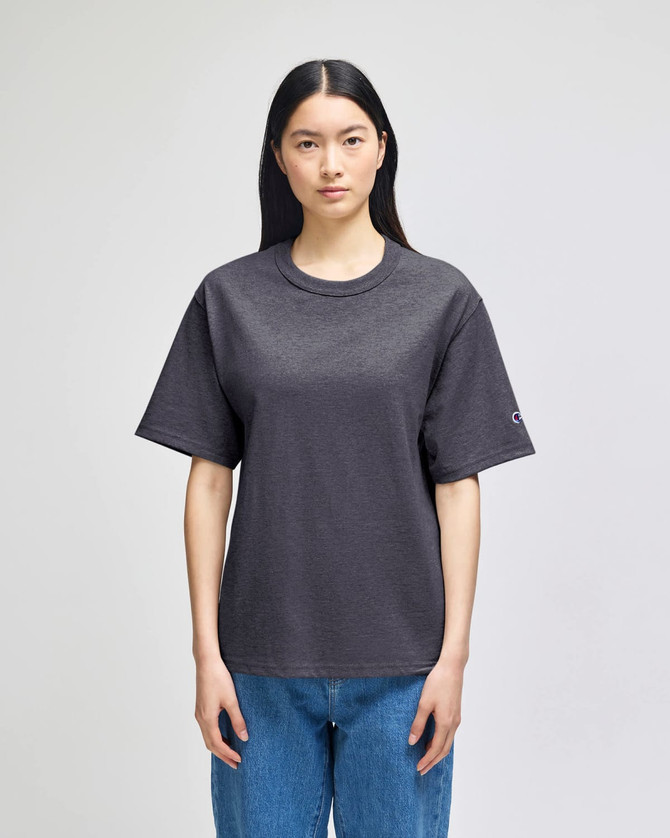 A black hooded sweatshirt featuring a logo, displayed on a model against a plain background.