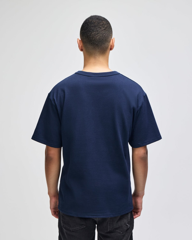 A navy blue Champion Adult Heritage Jersey T-Shirt viewed from the back. It features short sleeves and a relaxed fit.