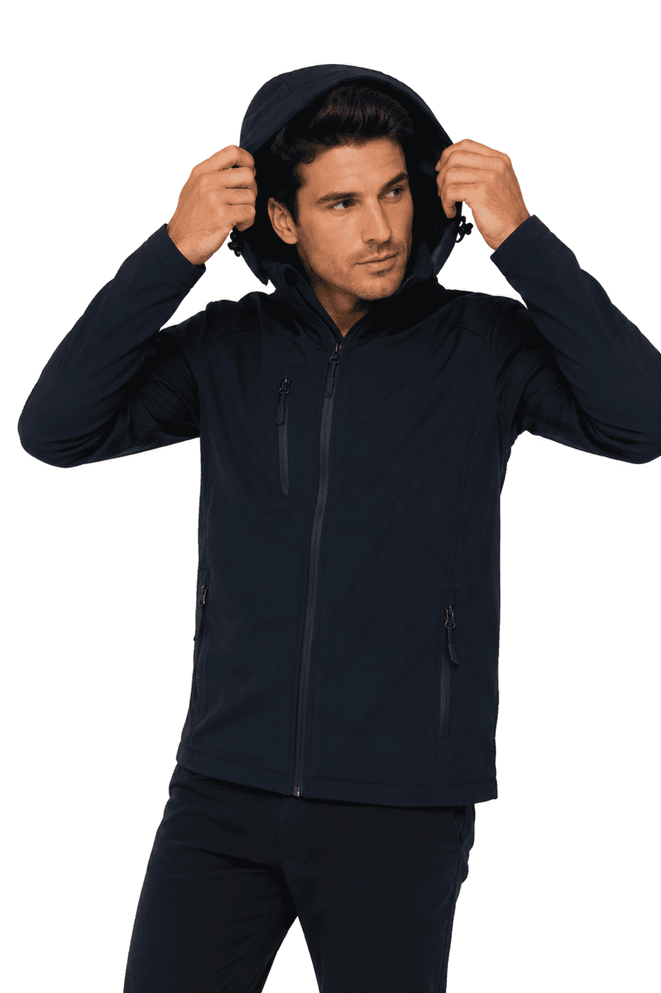 A man wearing a navy soft shell jacket with a hood, featuring zippered pockets and a fitted design.