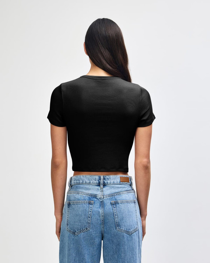 A black cropped fitted T-shirt with short sleeves, viewed from the back, paired with high-waisted denim jeans.