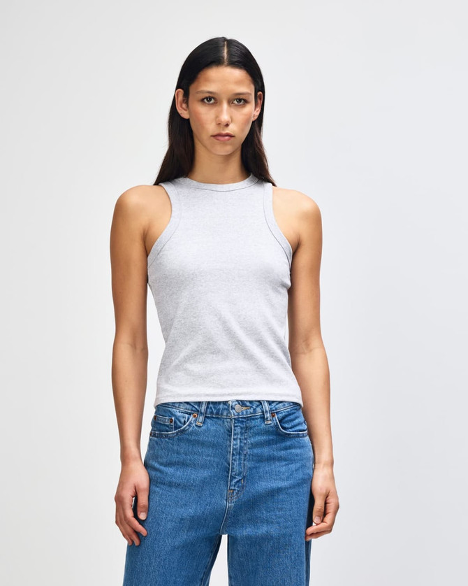 A fitted grey tank top worn by a woman, paired with blue jeans, displayed against a plain background.