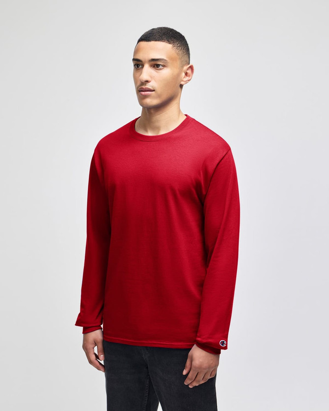 A red long-sleeve t-shirt on a model, featuring a small logo on the sleeve. The fabric appears soft and casual.