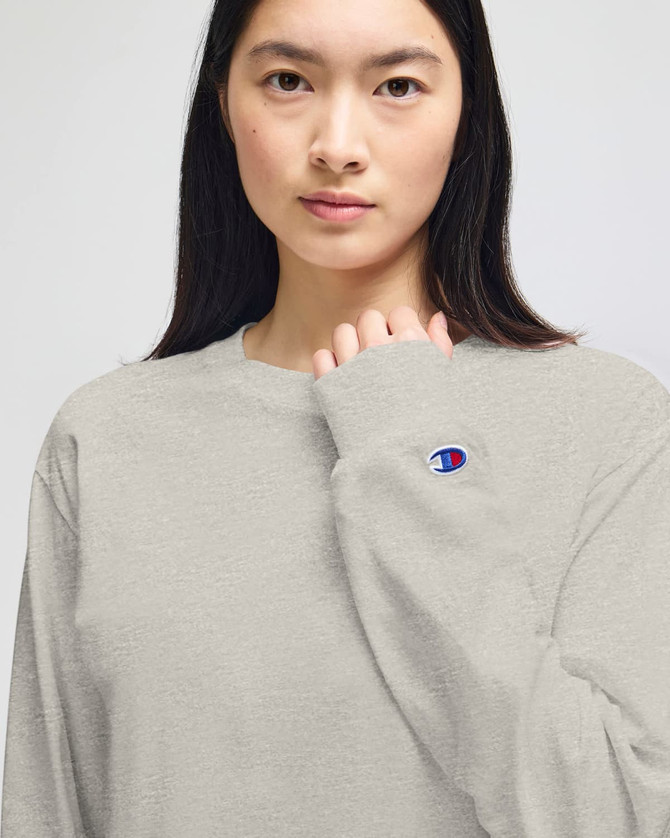 A light grey long-sleeve t-shirt featuring a branded logo on the sleeve.