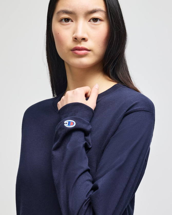 A long-sleeve navy t-shirt with a logo on the sleeve, featured on a model.