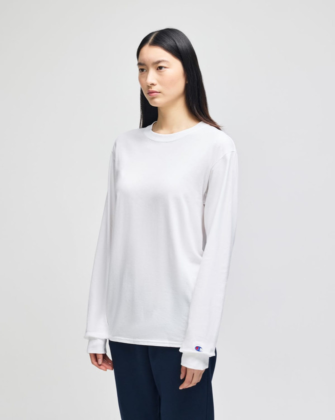 A white long-sleeve t-shirt featuring a logo on the sleeve, displayed on a model against a plain background.