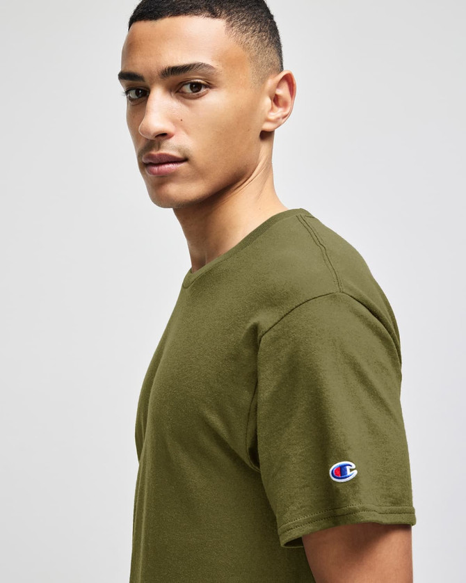 An olive green short sleeve T-shirt with a logo on the sleeve, displayed on a model.