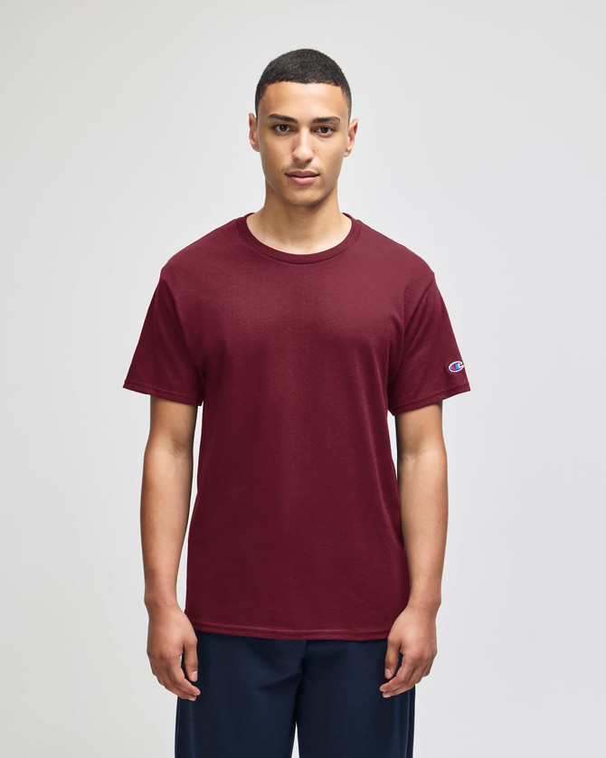 A maroon Champion adult jersey short sleeve T-shirt featuring a logo on the sleeve.