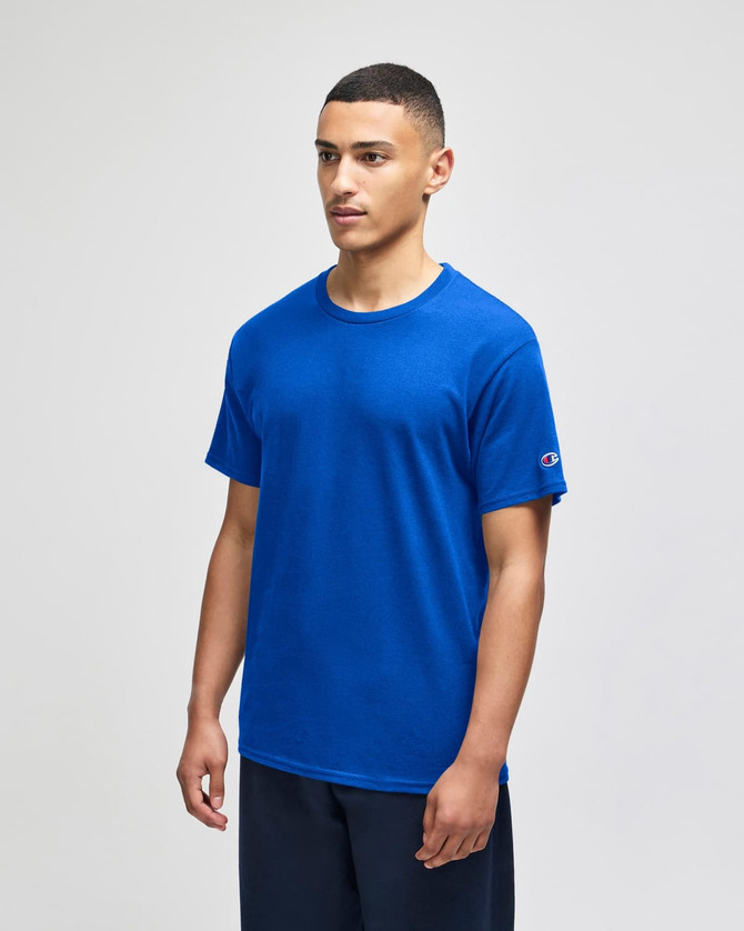A blue Champion Adult Jersey Short Sleeve T-Shirt on a male model, featuring a logo on the sleeve.