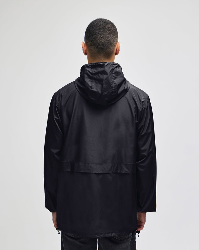 A black full-zip anorak jacket with a hood, featuring a simple design and a logo. Back view of the jacket.