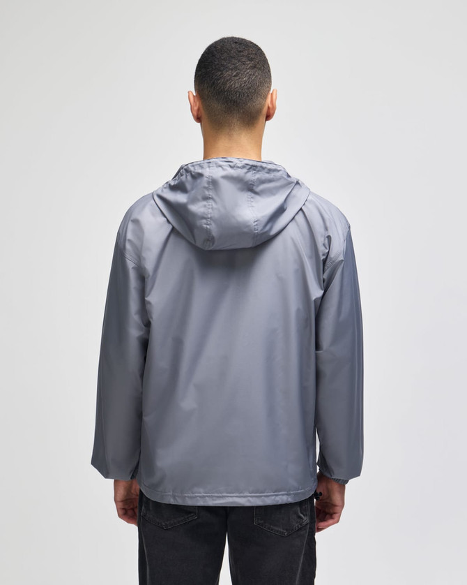 A grey packable anorak jacket viewed from the back, featuring a hood and a minimalist design.