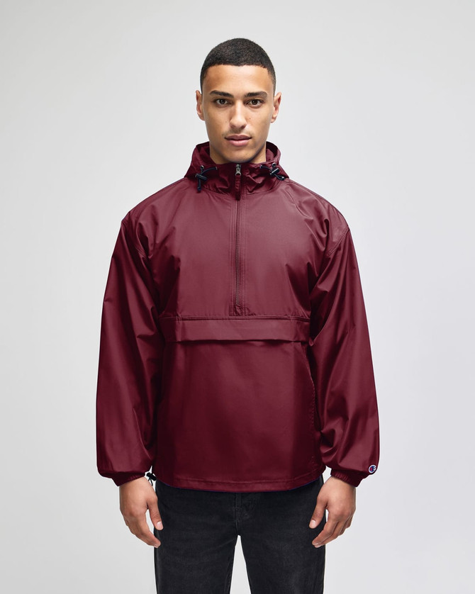 A maroon packable anorak jacket with a hood, featuring long sleeves and a front pocket. Includes a logo.