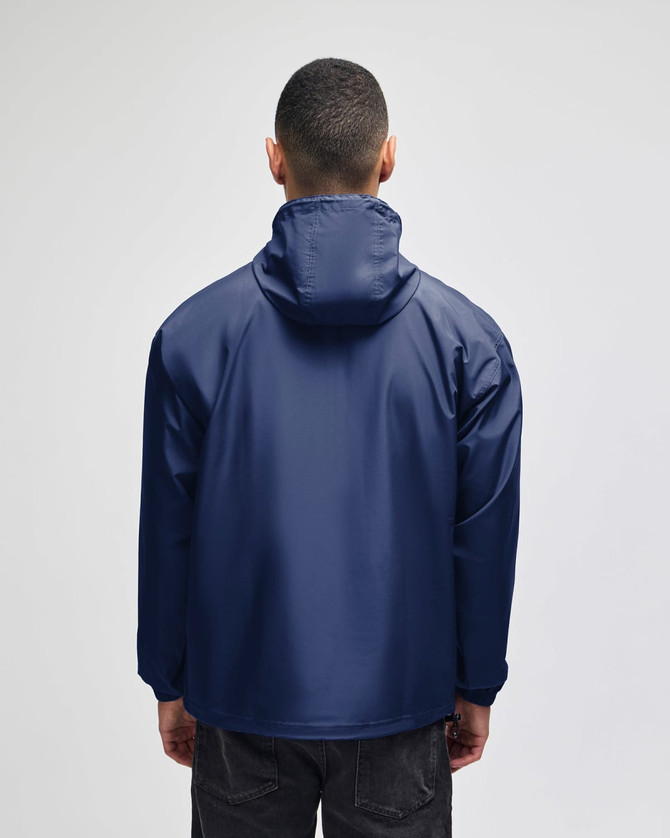 A navy blue packable anorak jacket featuring a hood and a logo on the back. Suitable for rain protection.