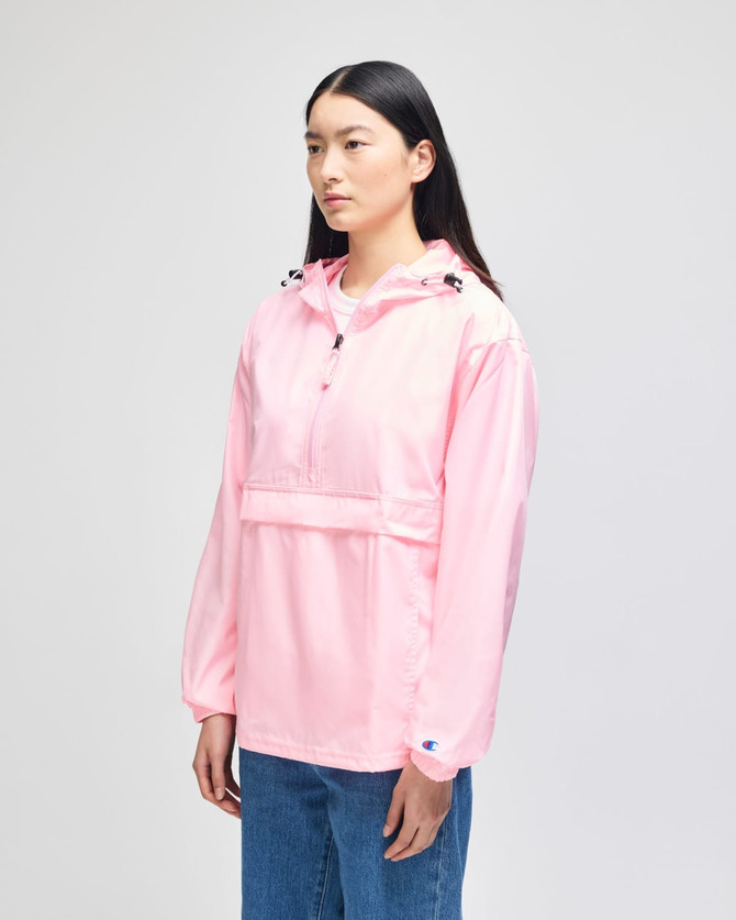 A pink packable anorak jacket for adults, featuring a hood and a front pocket, with a logo on the sleeve.