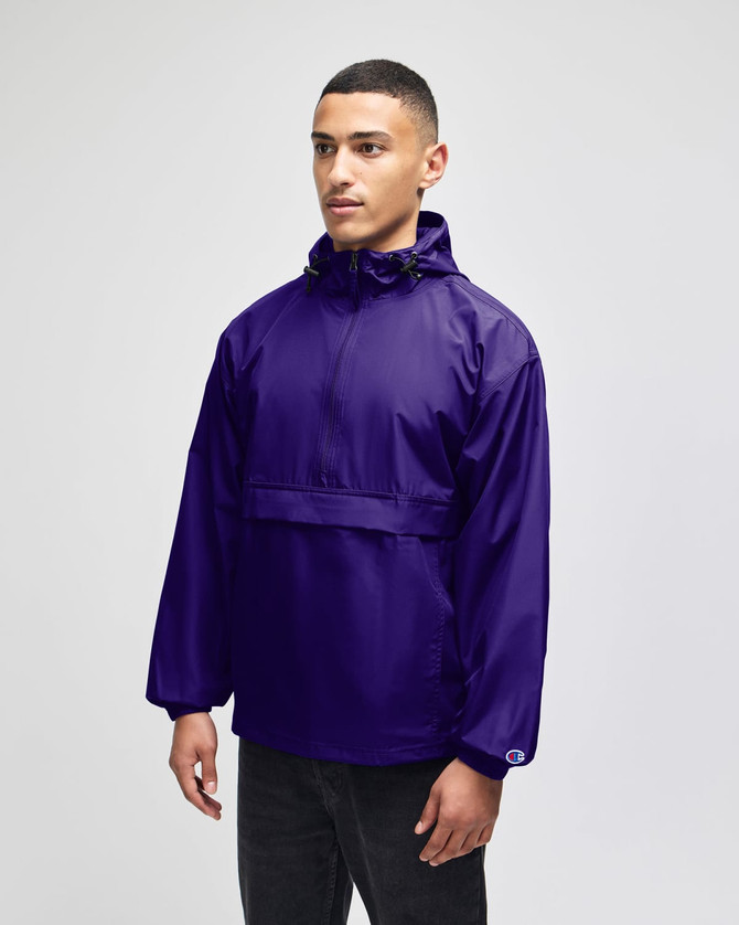 A purple packable anorak jacket with a hood and a front pocket, featuring a logo on the sleeve.