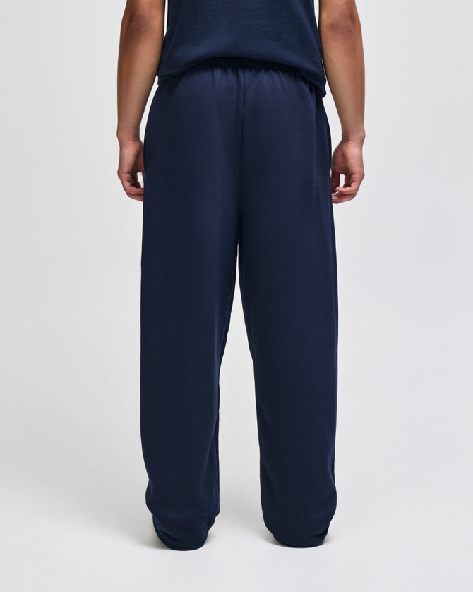 Navy blue open-bottom fleece pants with pockets, featuring a relaxed fit, viewed from the back.