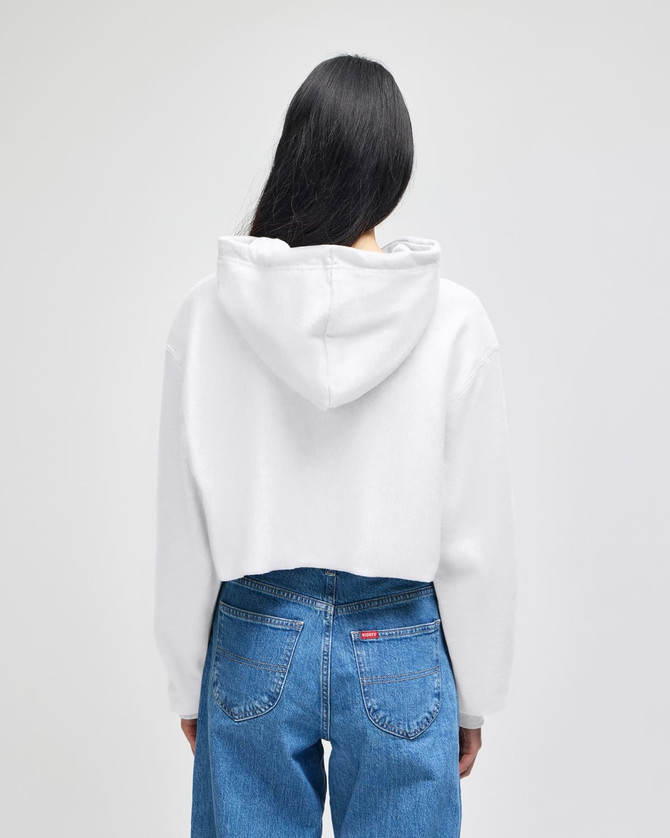A white cropped hoodie with a hood, displayed from the back, paired with blue jeans. It features a logo.