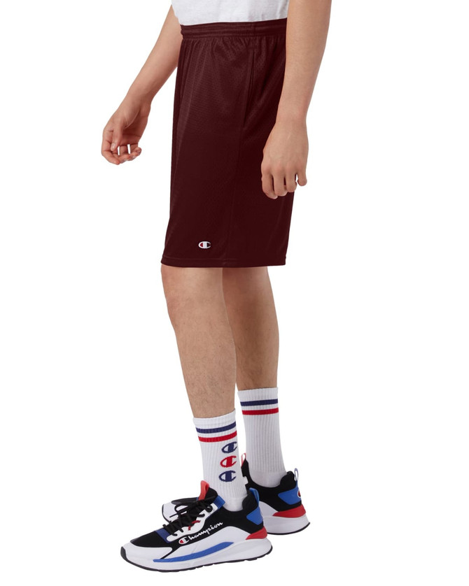 Maroon mesh shorts with pockets, featuring a logo, displayed on a person wearing sporty shoes and socks.