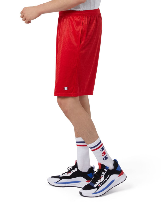 Red mesh sports shorts with pockets, featuring a logo, worn with white and red striped socks and athletic shoes.