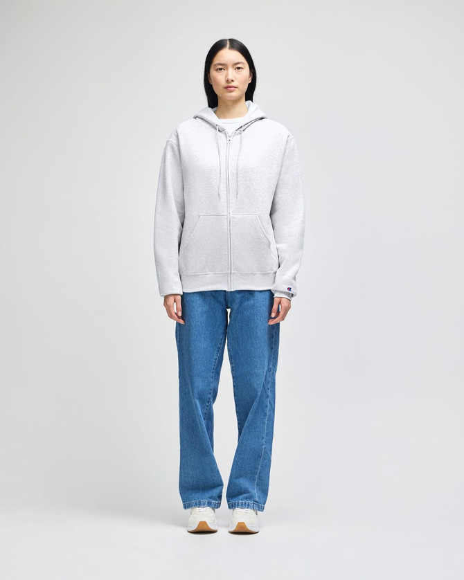 A grey full-zip hooded sweatshirt with a front pocket and a logo, paired with blue jeans.
