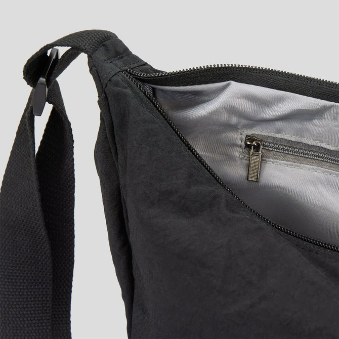 A black bag with a zippered opening and an interior pocket, featuring a sturdy strap. It has a simple, sleek design.