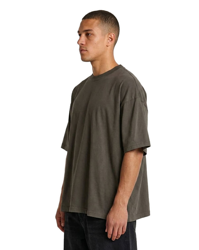 An oversized T-shirt in faded olive green, made of 230gsm 100% organic cotton, styled with a relaxed fit.