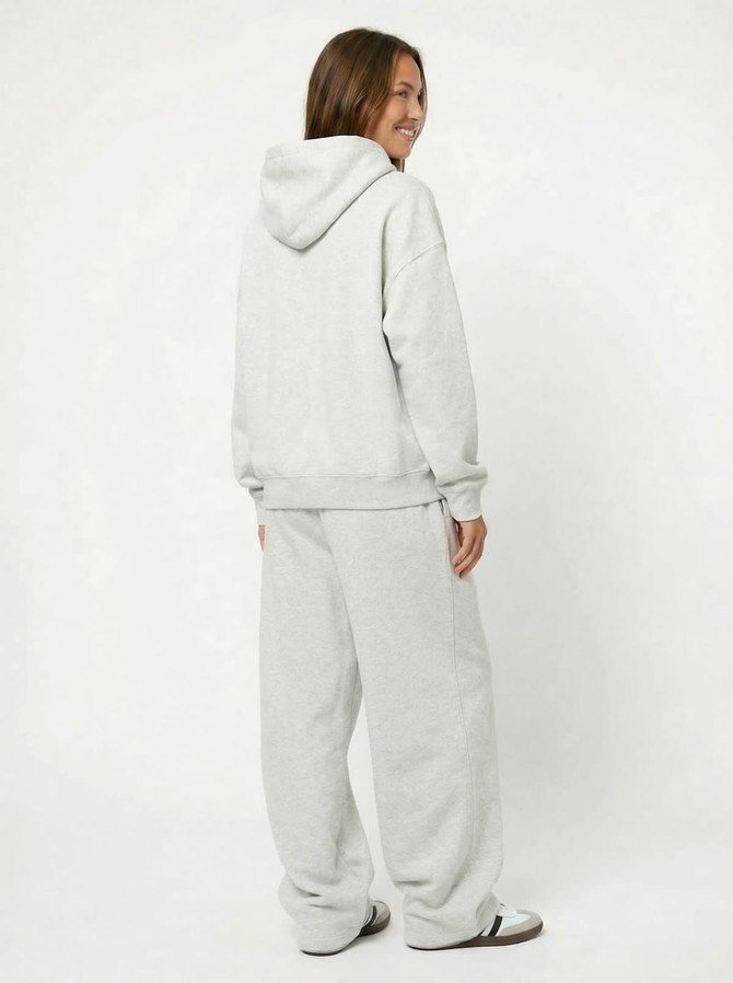 A pair of grey unisex wide-leg fleece pants displayed on a person from the back, wearing a matching hoodie.