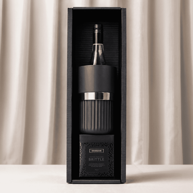 A black gift box containing a wine bottle and a glass, with a branded logo on the packaging.