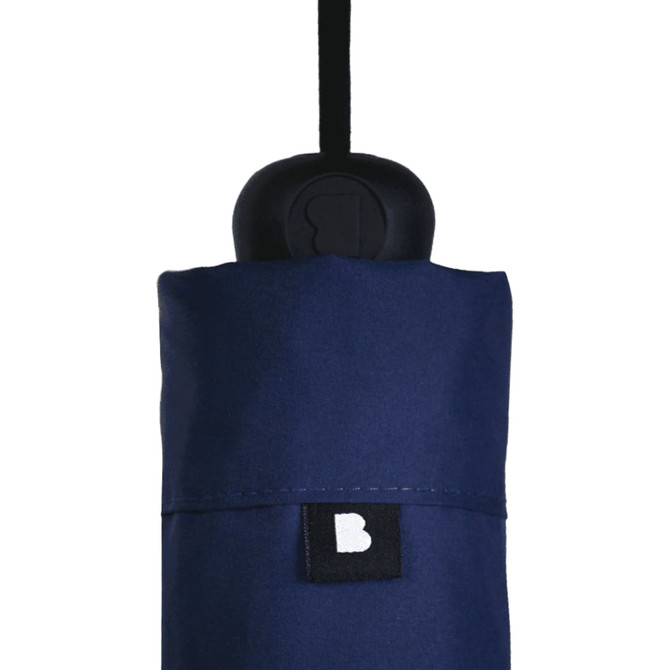 A navy blue umbrella set with a black handle, featuring a branding label on the cover.