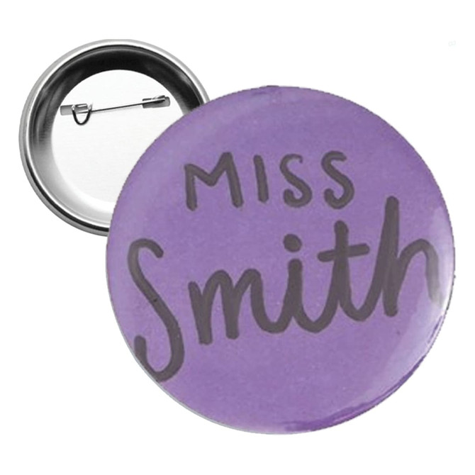 A round 58mm button badge in purple with a silver backing and a pin mechanism.