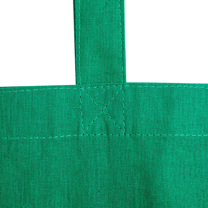 A close-up view of a green calico tote bag with stitched straps and no gusset. Features a logo.