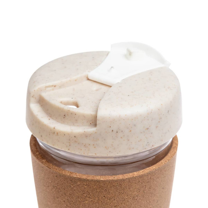 A reusable coffee cup featuring a cork band, with a lid made from a sustainable material that has a speckled design.