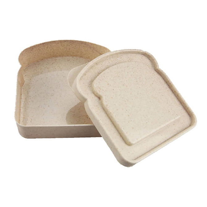 A bamboo sandwich box in a light beige colour, featuring a removable lid shaped like a slice of bread, with a logo.