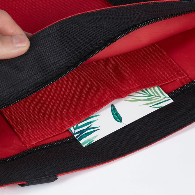 A red tote bag with a black trim, featuring an interior pocket and a decorative card inside.