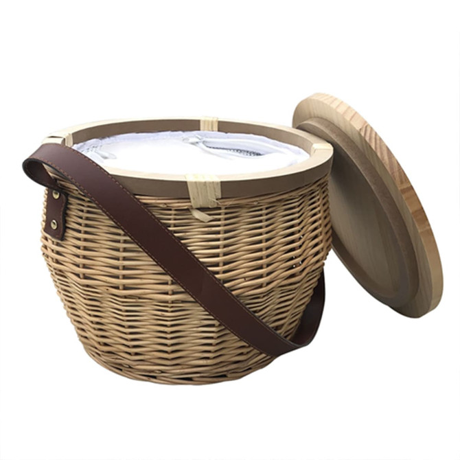 A round wicker picnic cooler basket in natural tones with a wooden lid and a brown strap. It features a logo.