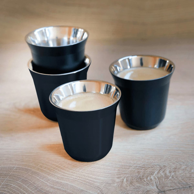 A set of four black espresso cups with metallic silver interiors, featuring a simple design and a logo.