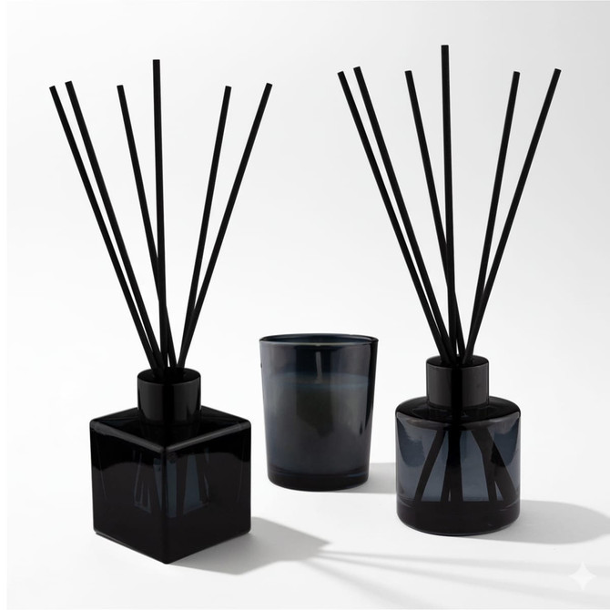 An Aroma Diffuser and Candle Gift box featuring two black diffusers and a matching candle, all in sleek glass containers.